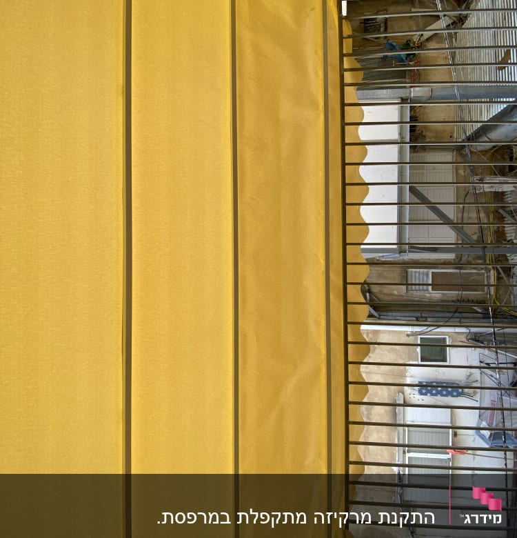 סוכך צהוב עם קפלים על מרפסת